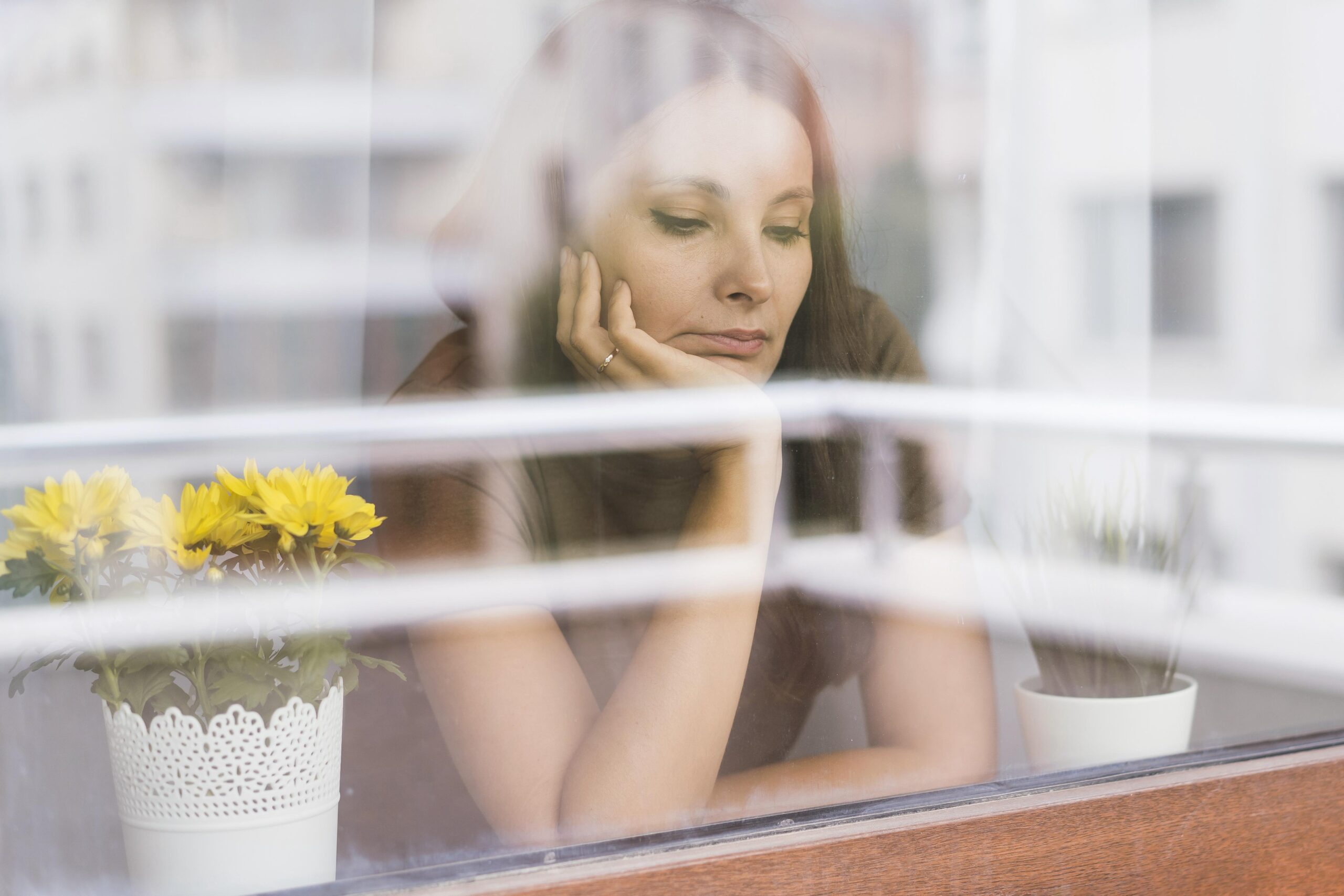 Woman reflecting by window